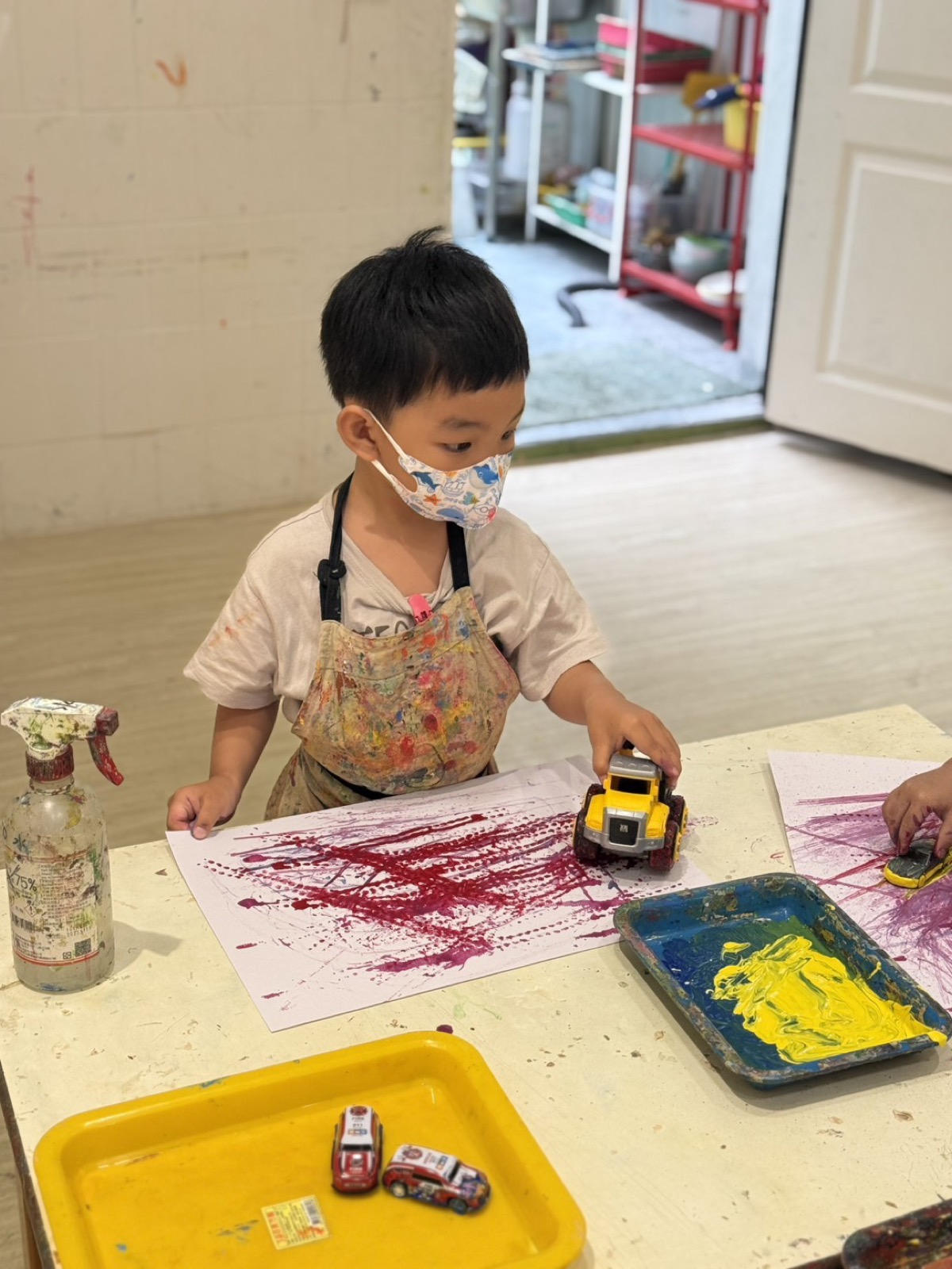孩子使用玩具車與顏料創作軌跡