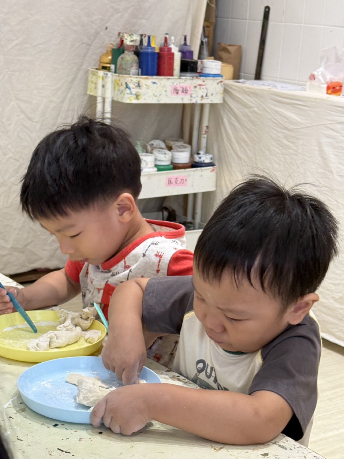 兩位孩子在盤中操作黏土材料