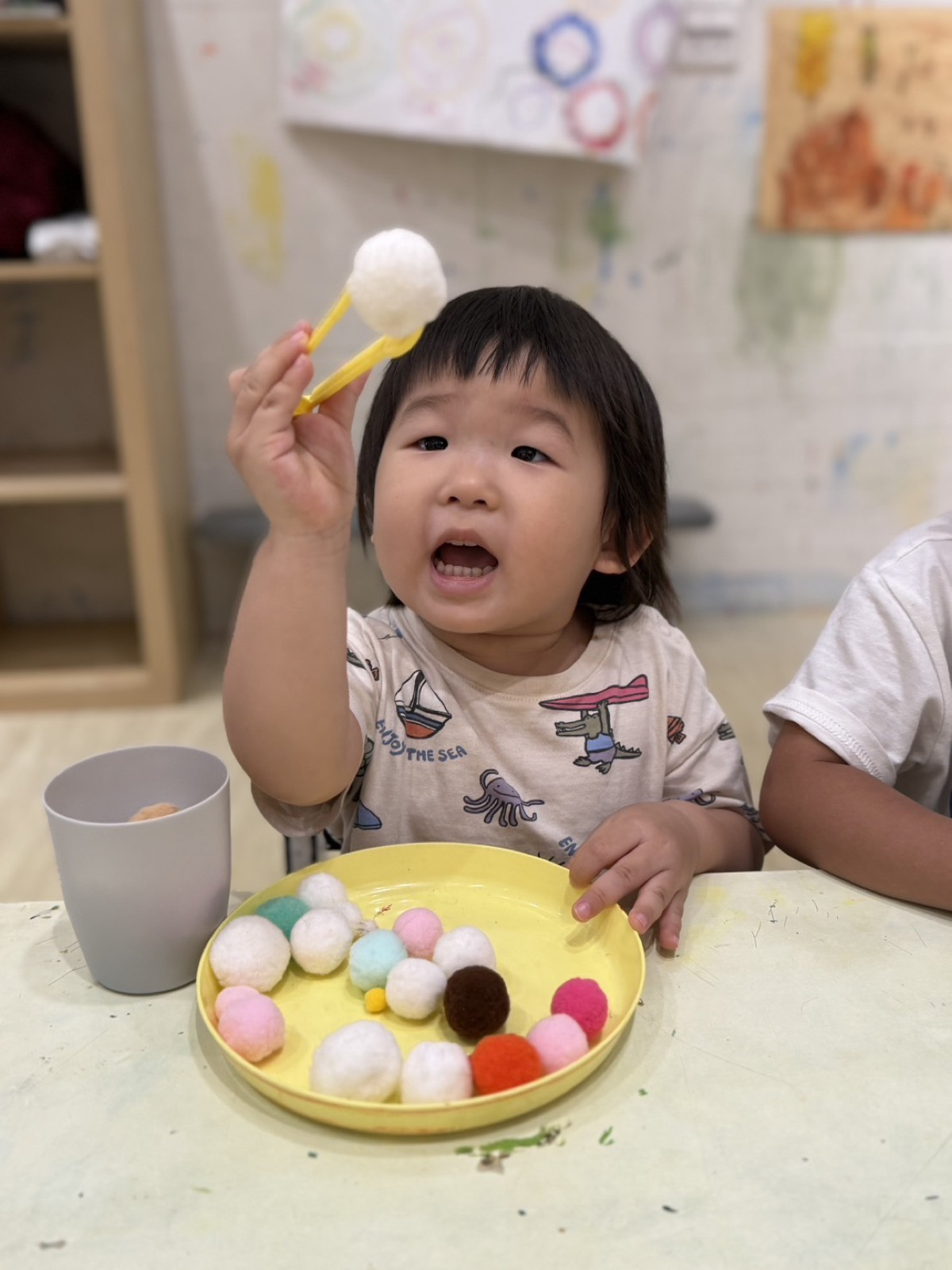 孩子拿起毛球進行感官探索
