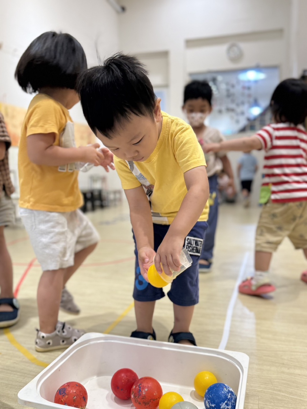 孩子把球放入收納盒中
