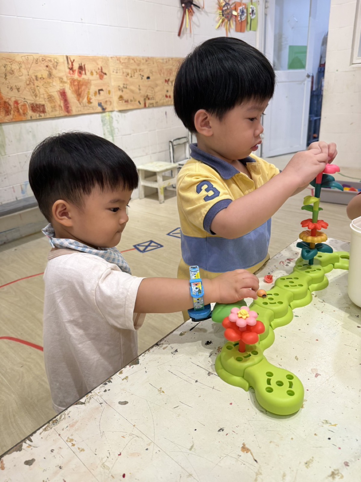 兩位孩子合作組裝花朵玩具