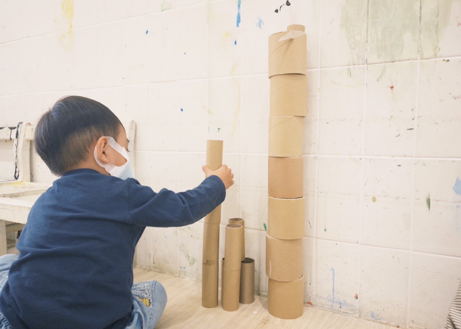 孩子用紙筒堆疊成高塔