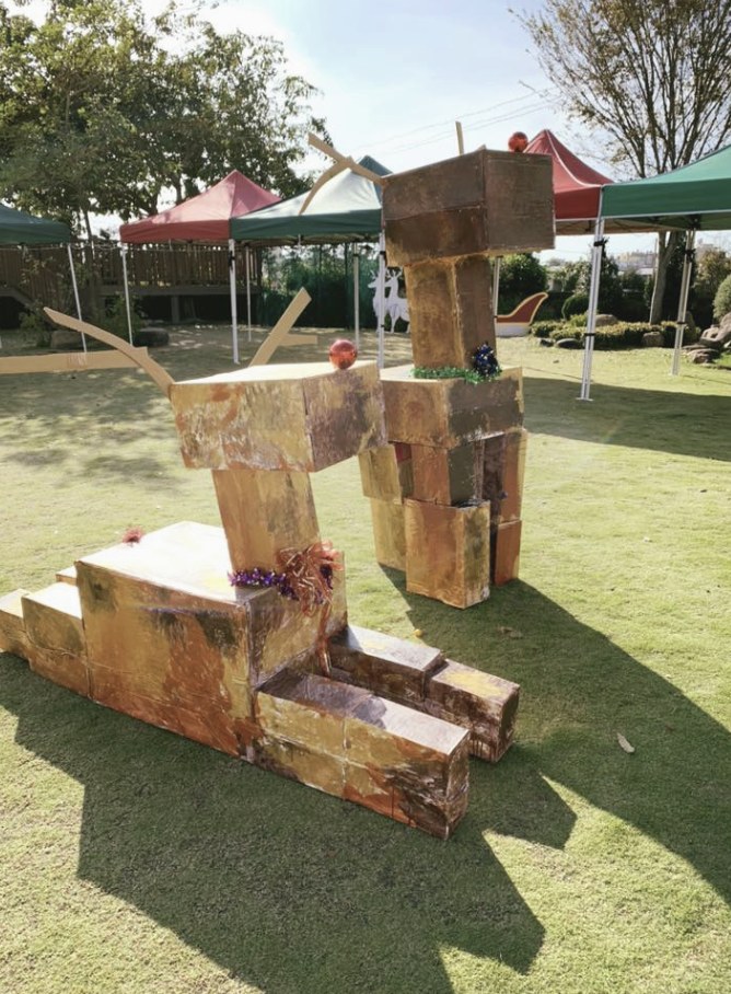 戶外草地上的大型金色紙箱裝置作品