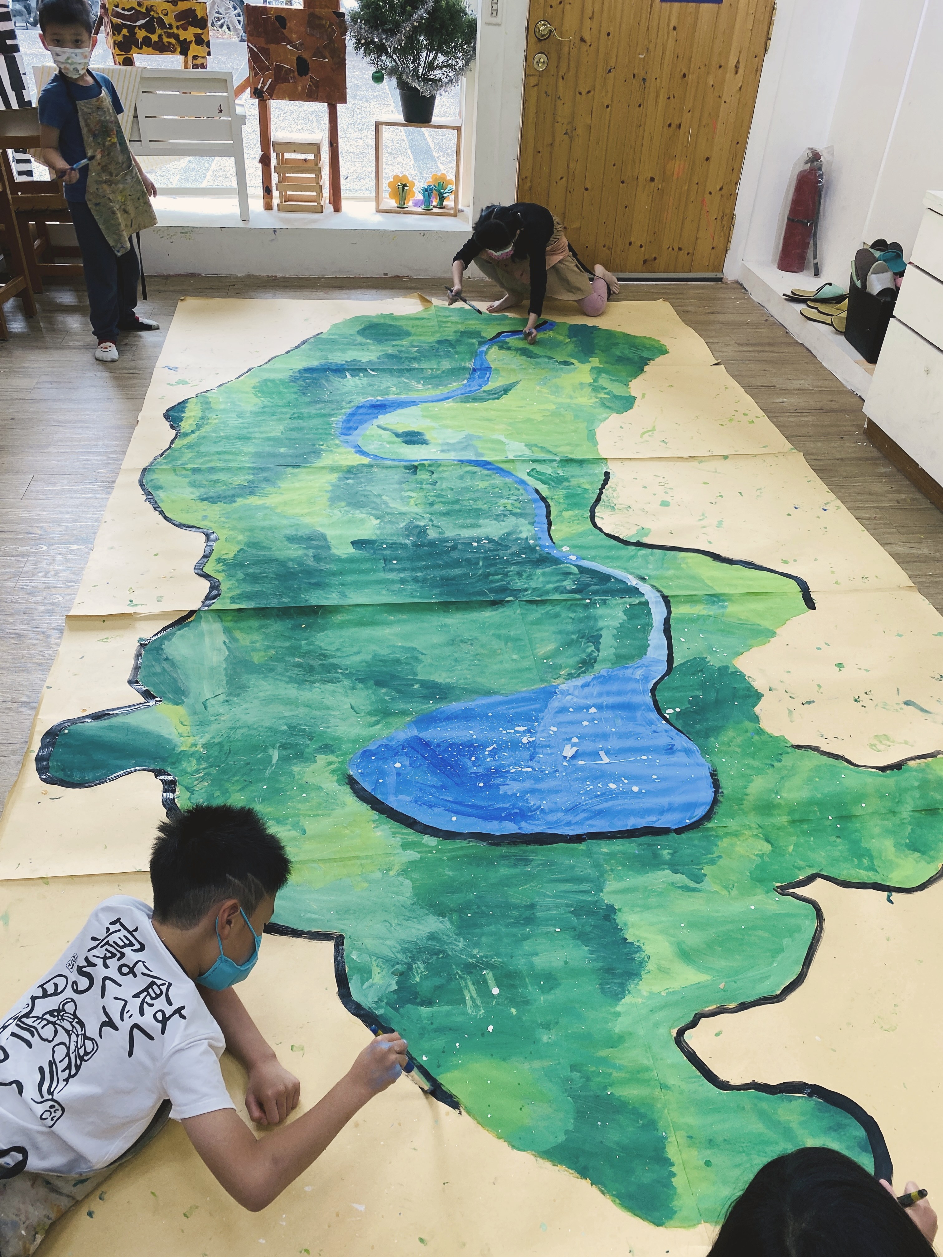 孩子們在地面共同繪製大型河流地圖