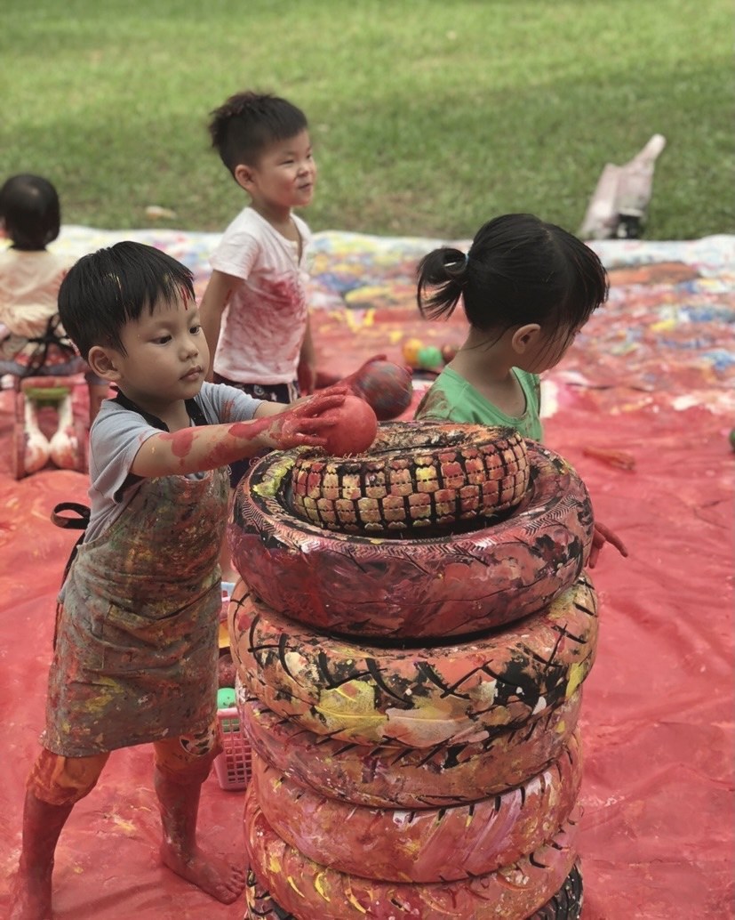 孩子在戶外為輪胎裝置塗上顏色